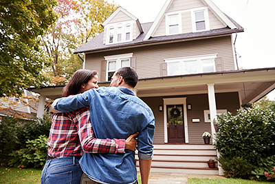 a couple walking up to the rear view of their home