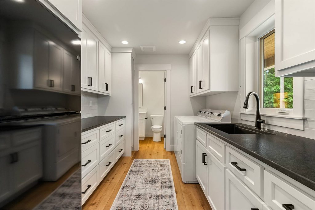 a spacious laundry room with a fridge and a full bath