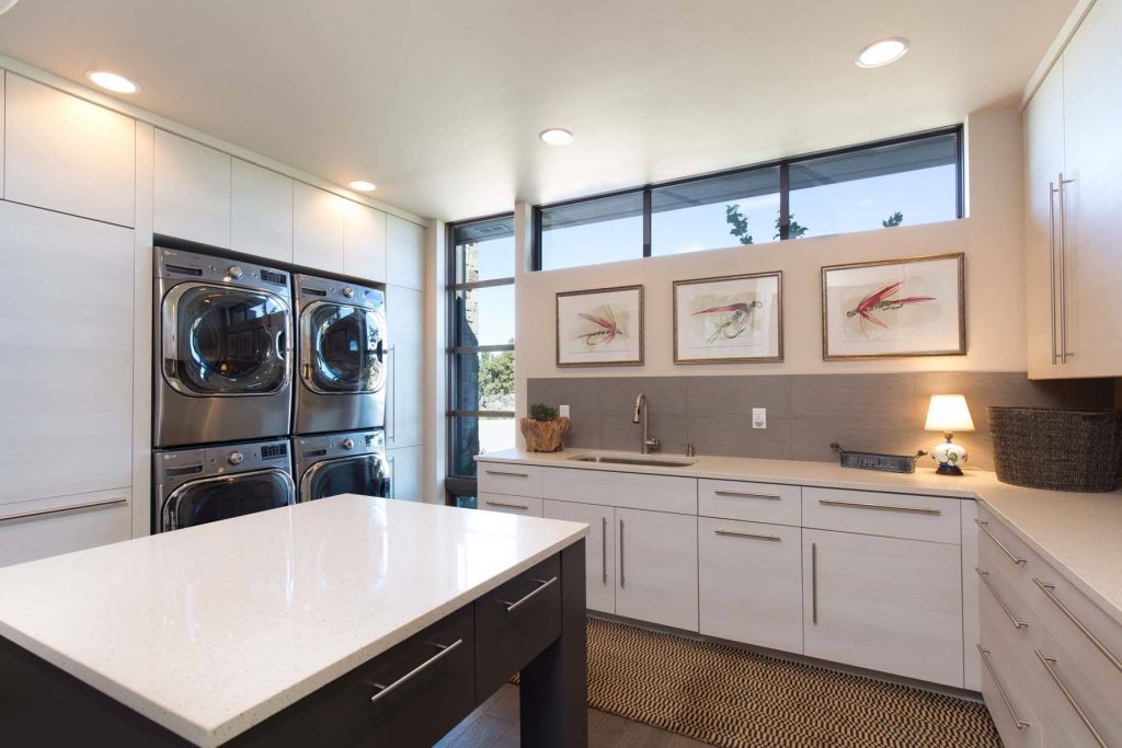 a huge, inviting laundry room with double appliances and a center island