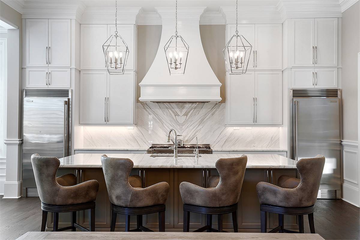 a luxe kitchen with a symmetrical cabinet and fridge layout around the range