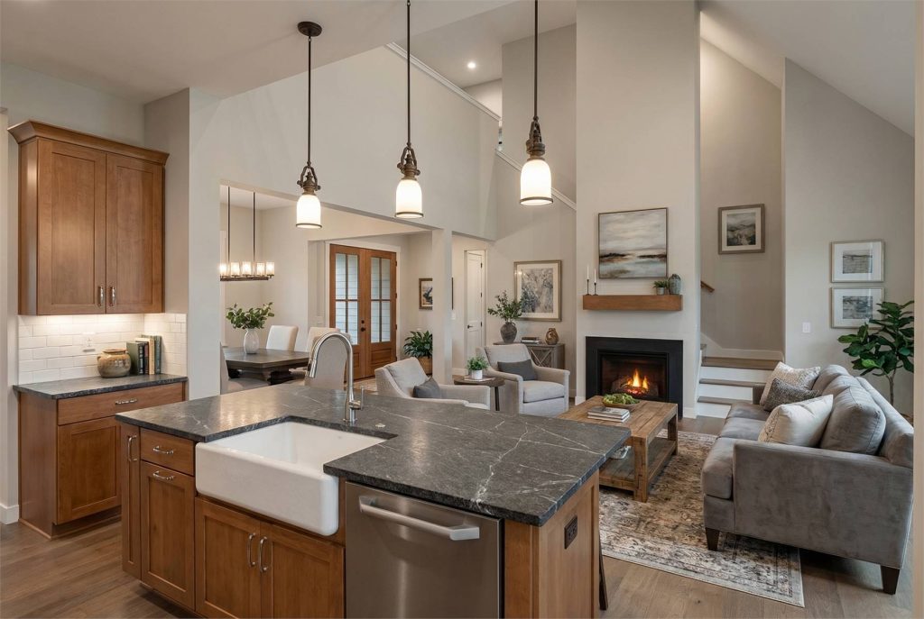 Modern farmhouse kitchen with large island, wood cabinets, pendant lighting, stainless steel appliances, and open floor plan