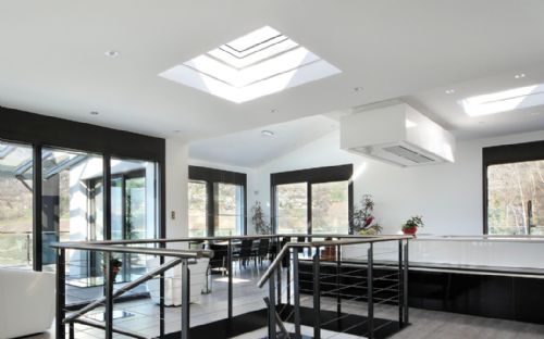 A Contemporary Home with Curved Flat Roof Skylights to Capture Plenty of Sun