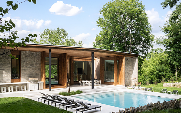 The Rear Outdoor Living Area of a House with Wood Cladding Alongside Stone