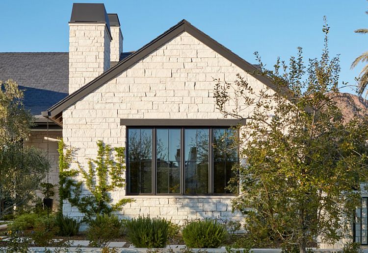 A Southwestern Home with Chic Wood Windows with Black Frames Offset by Warm Stone